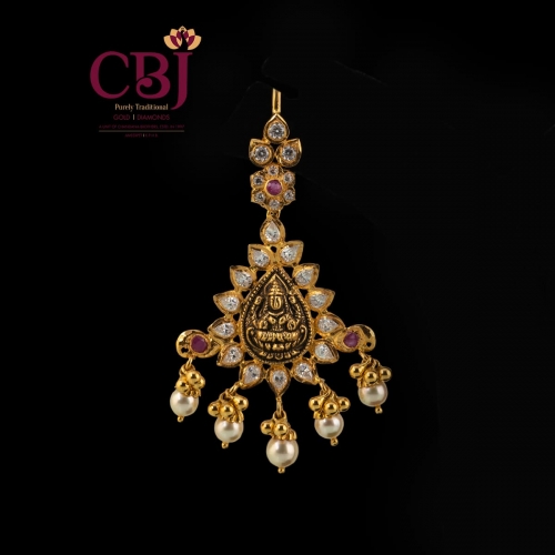 A unique maang tikka with an understated antique design featuring traditional elements.