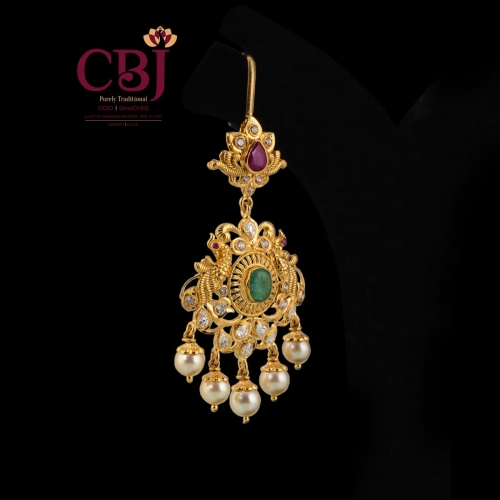 A simple maang tikka comprising of cz and emerald stones to enhance your traditional look.