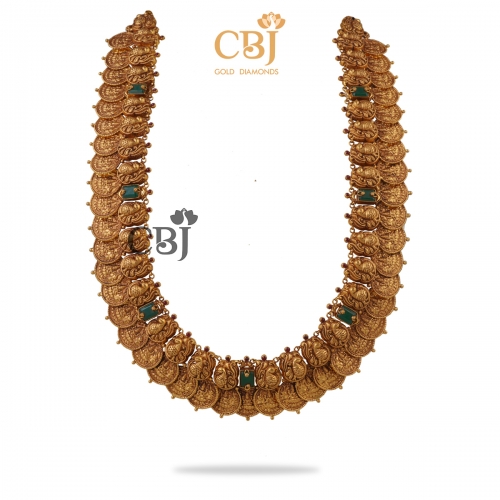 A grand heavy kasumala studded with emerald stones, exclusively for special occasions.