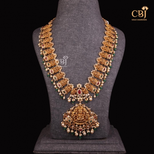 Indulge in Exquisite Pachi Creations with this Lakshmi Haram featuring CZs, pearls, rubies and emeralds.