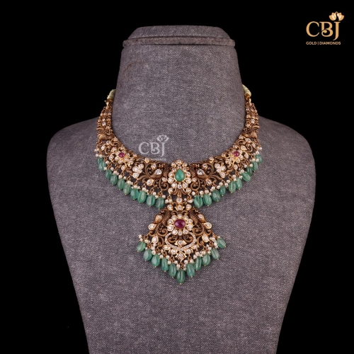 Experience the Legacy of Pachi Craftsmanship with this short necklace featuring peacock ???? motifs decorated with CZs, pearls and emerald stones.