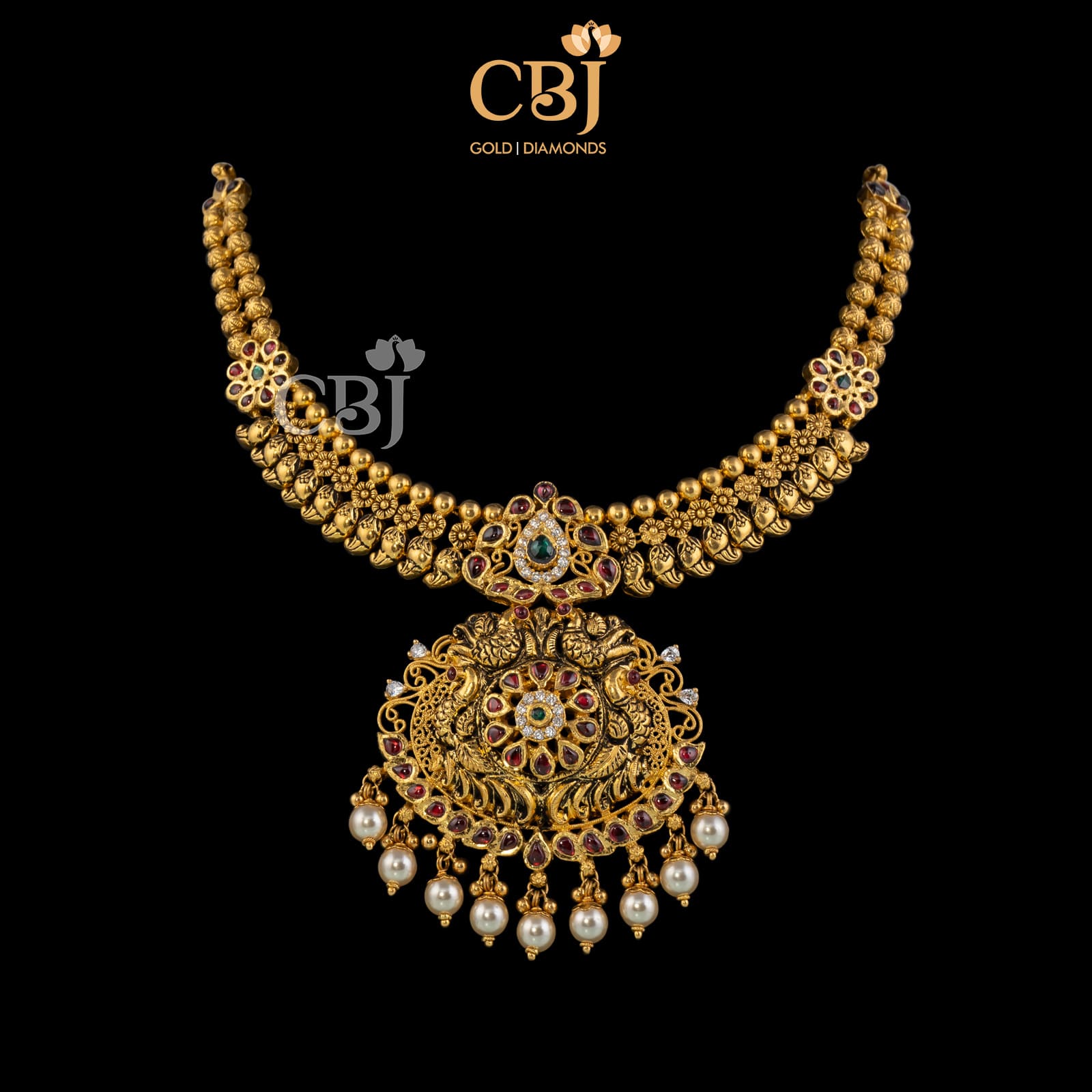 An antique necklace featuring rubies, emeralds and pearl drops.