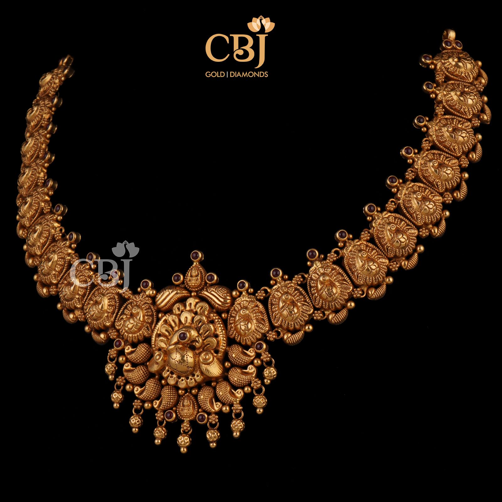 A deep nakas necklace featuring symmetrical peacock engravings and a stunning centrepiece.