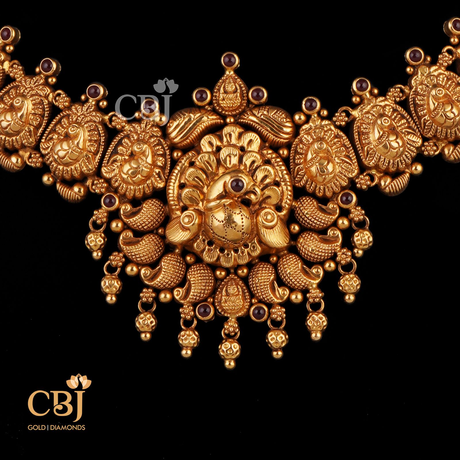A deep nakas necklace featuring symmetrical peacock engravings and a stunning centrepiece.