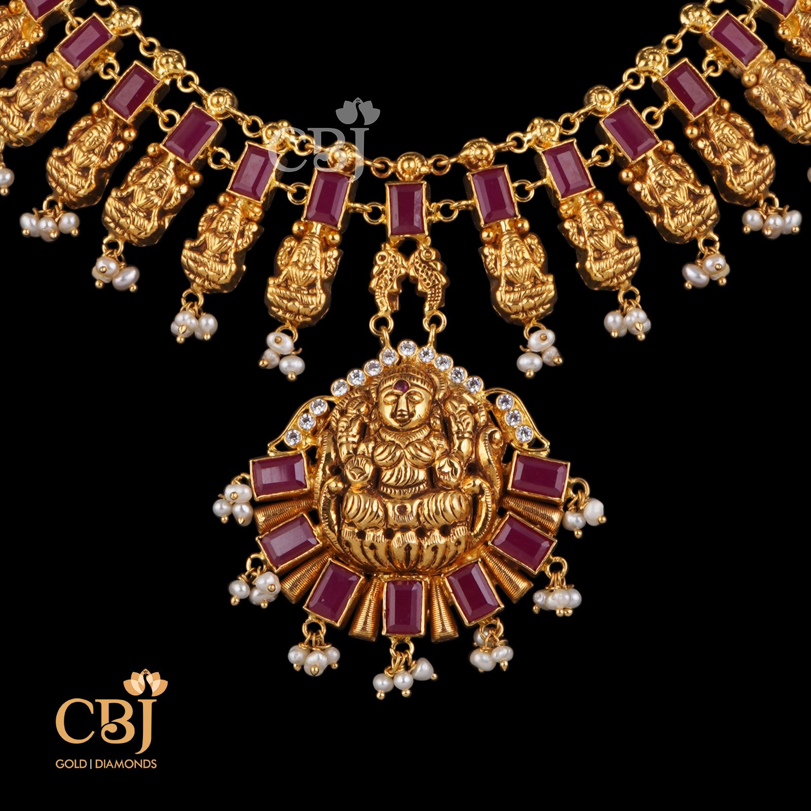 Dainty red rubies complimenting pure 22k gold with a stunning centrepiece featuring Goddess Lakshmi.