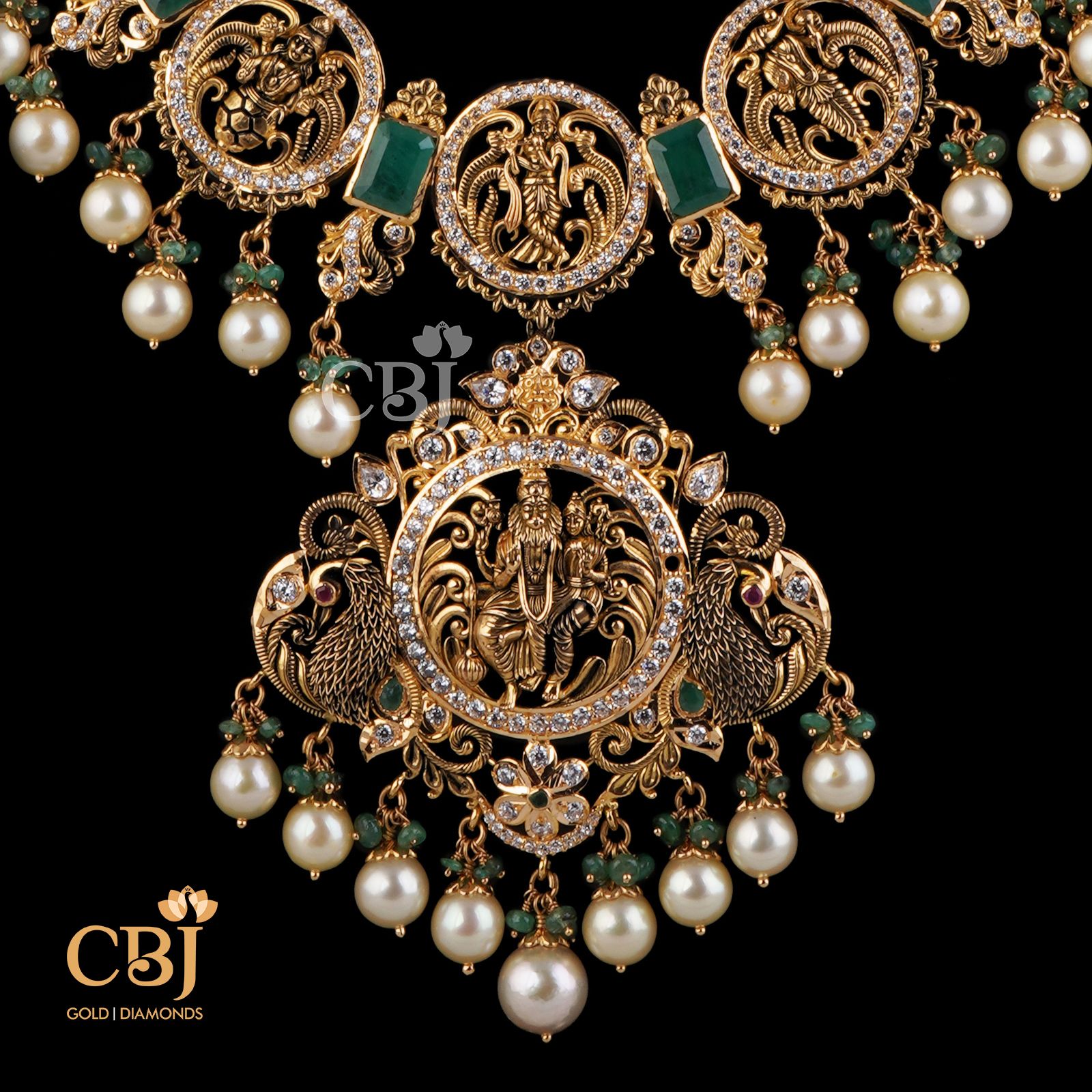 This stunning Dasavataram Semi long haram is an incredible marvel in design featuring emerald stones and suspended pearl drops.