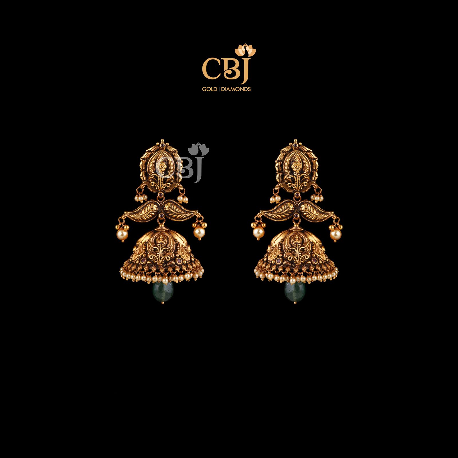 Antique jhumkas enhanced with nakashi workmanship with hanging emerald bells.