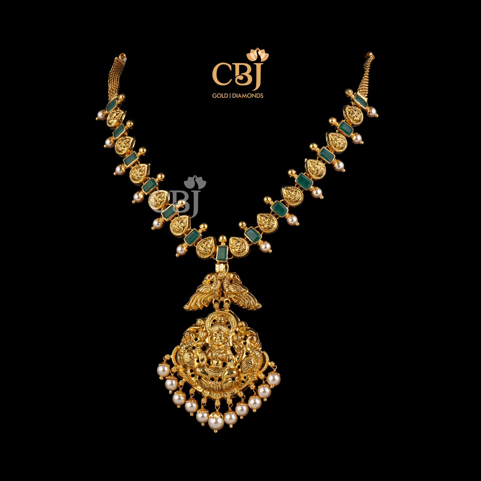 A classic traditional Lakshmi necklace studded with symmetrical emerald stones.
