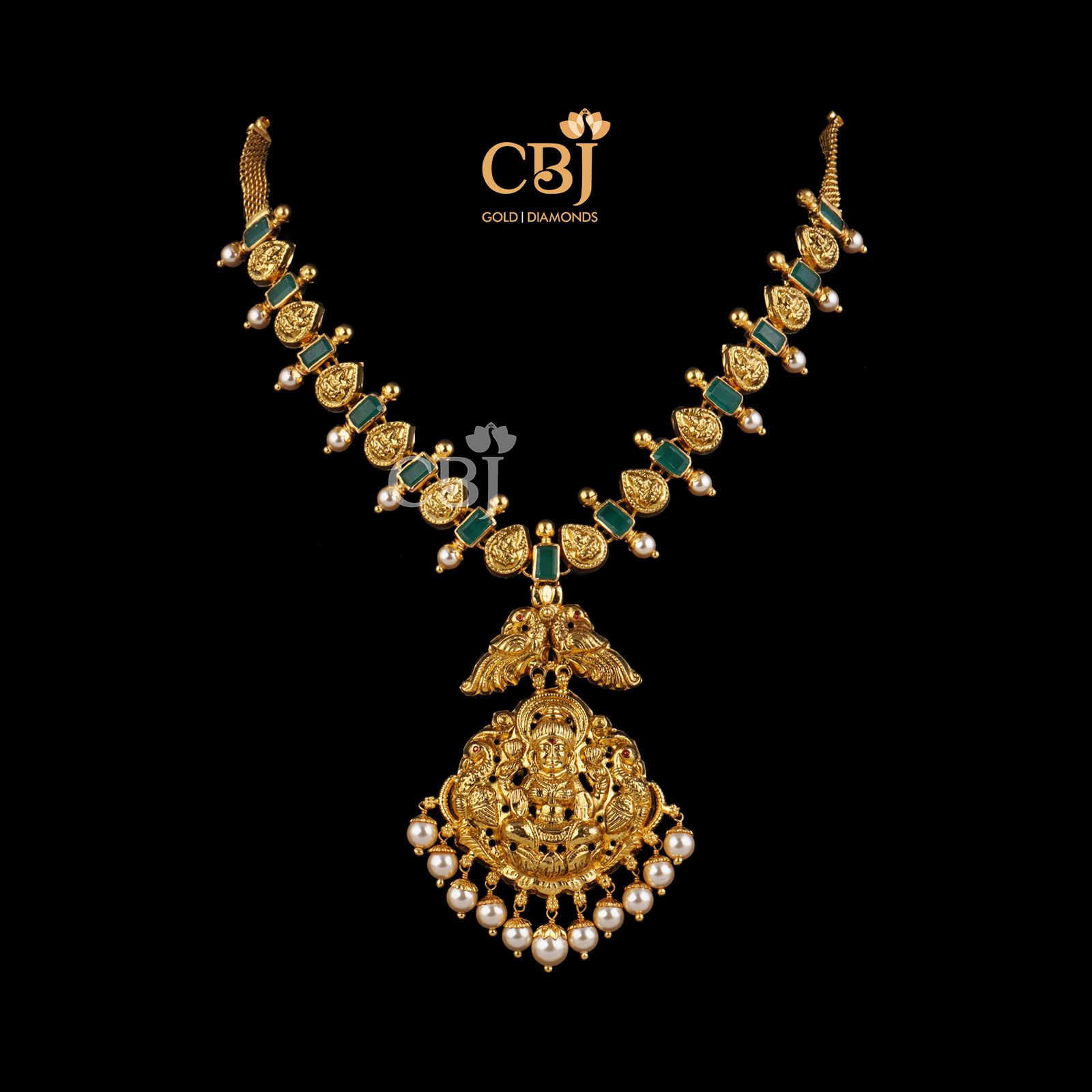 A classic traditional Lakshmi necklace studded with symmetrical emerald stones.