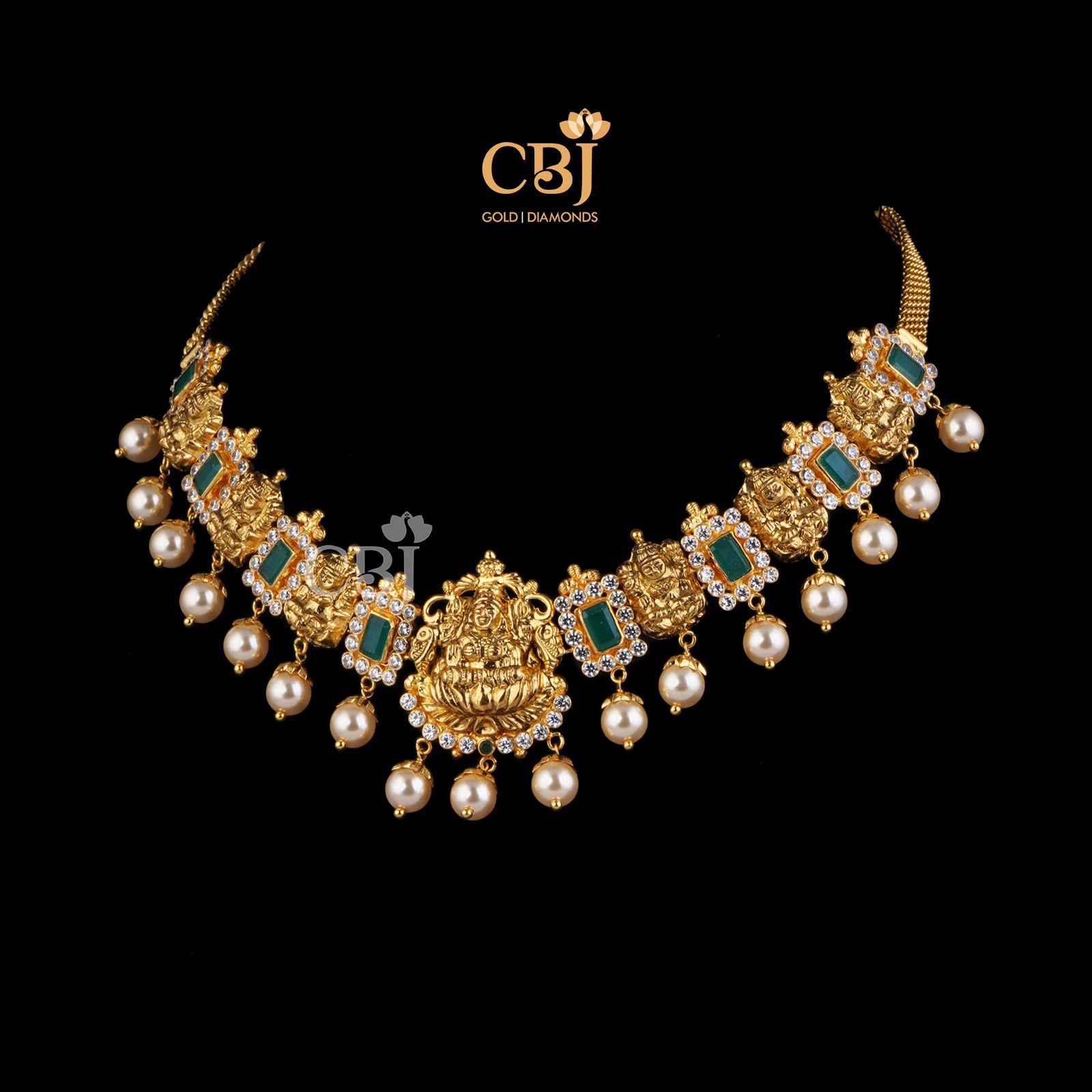 A simple short necklace studded with emerald stones surrounded with czs featuring suspended pearls.