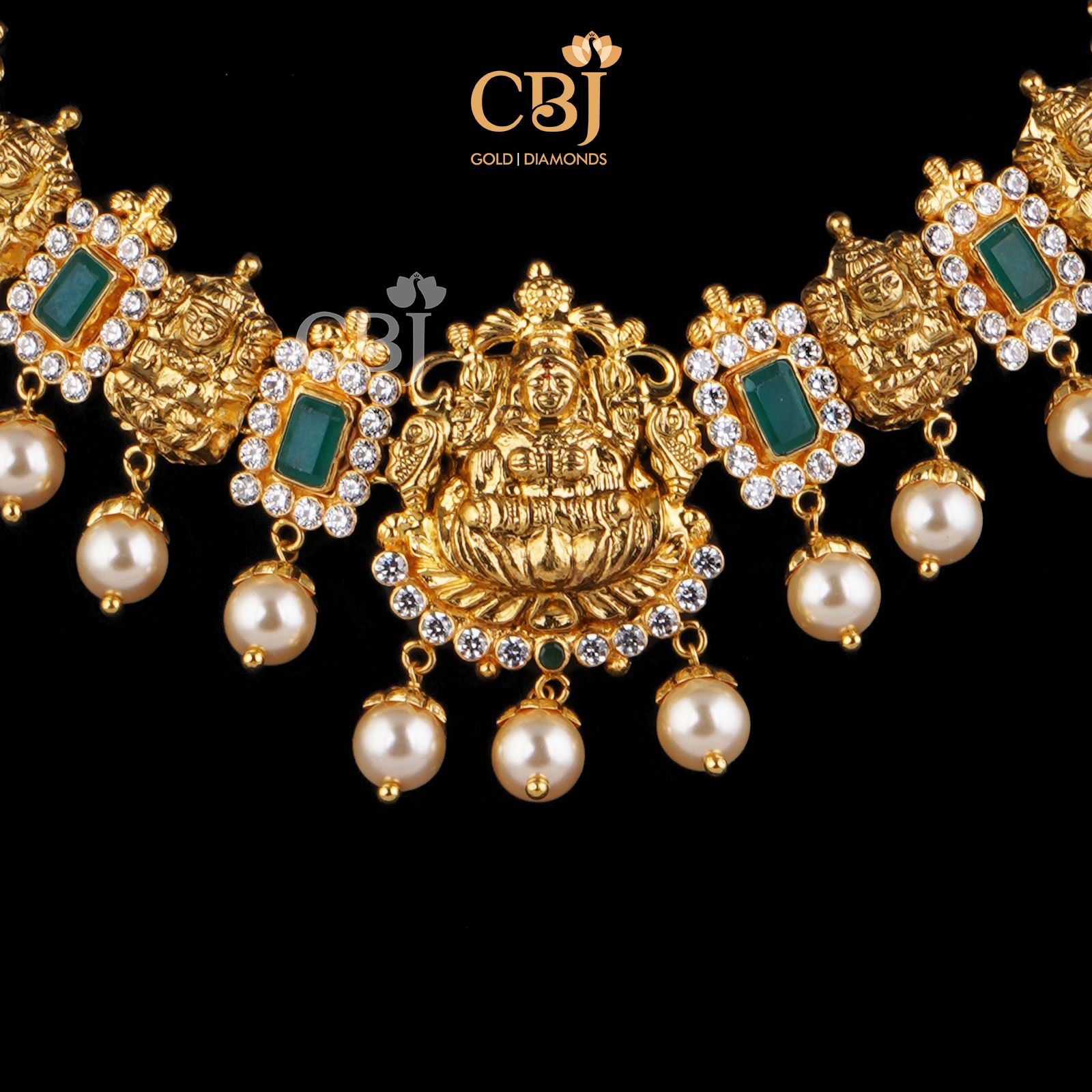 A simple short necklace studded with emerald stones surrounded with czs featuring suspended pearls.