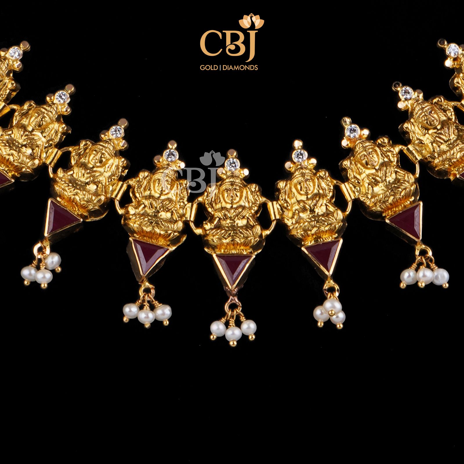 A divine design featuring Lakshmi motifs studded with ruby stones.