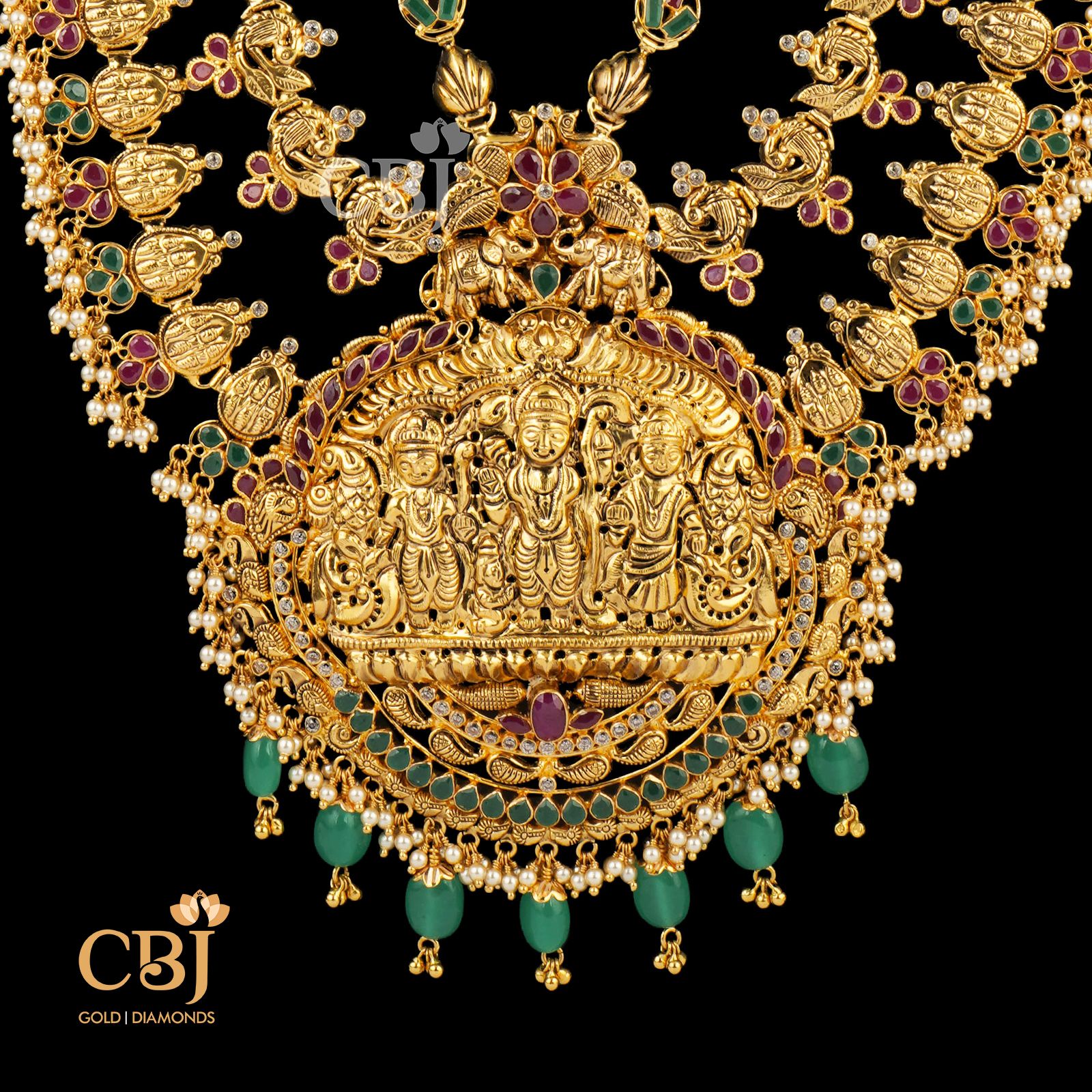A 3 step long haram with divine motifs featuring rubies and emeralds.