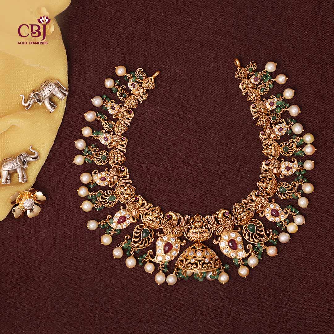 A multi coloured necklace featuring mango motifs adorned with CZs, rubies, emeralds and pearls. A visual artistry.