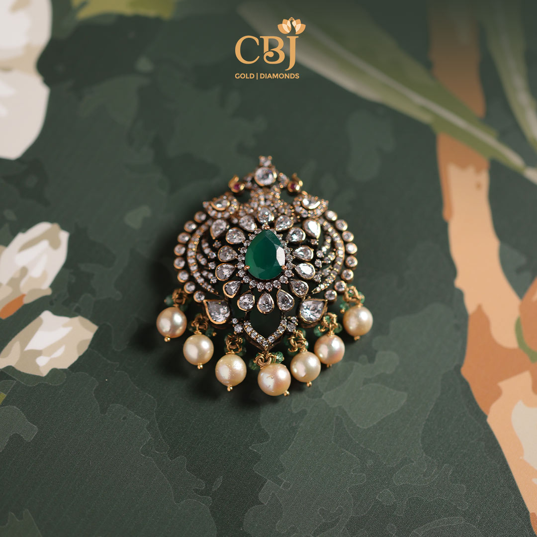 A scintillating pendant featuring CZ stones and an emerald drop as highlight.