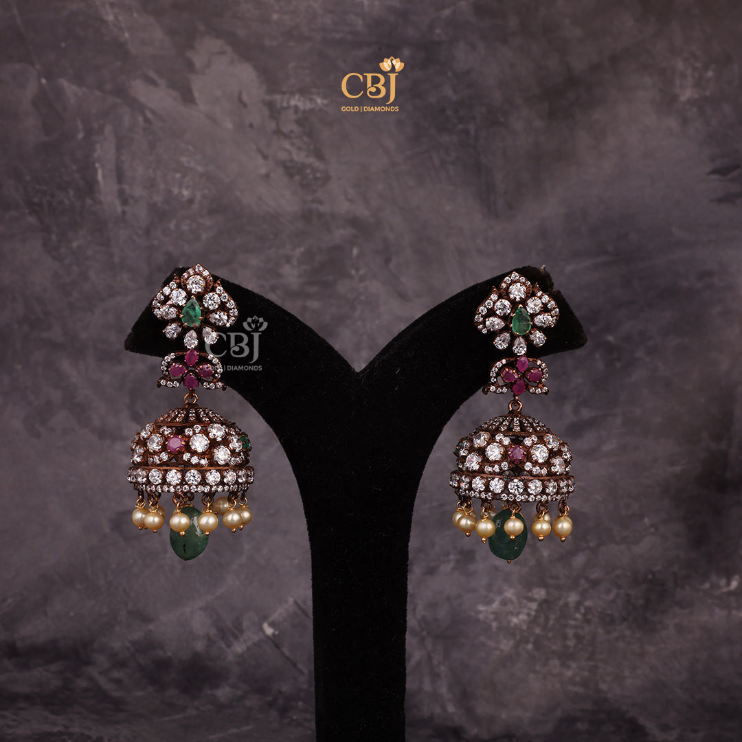 A scintillating designer jhumka featuring CZ stones, rubies, emeralds and pearls.