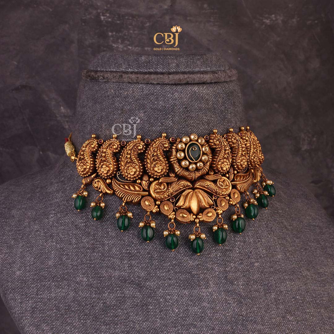 A one of a kind antique choker featuring paisley motifs and emerald beads.