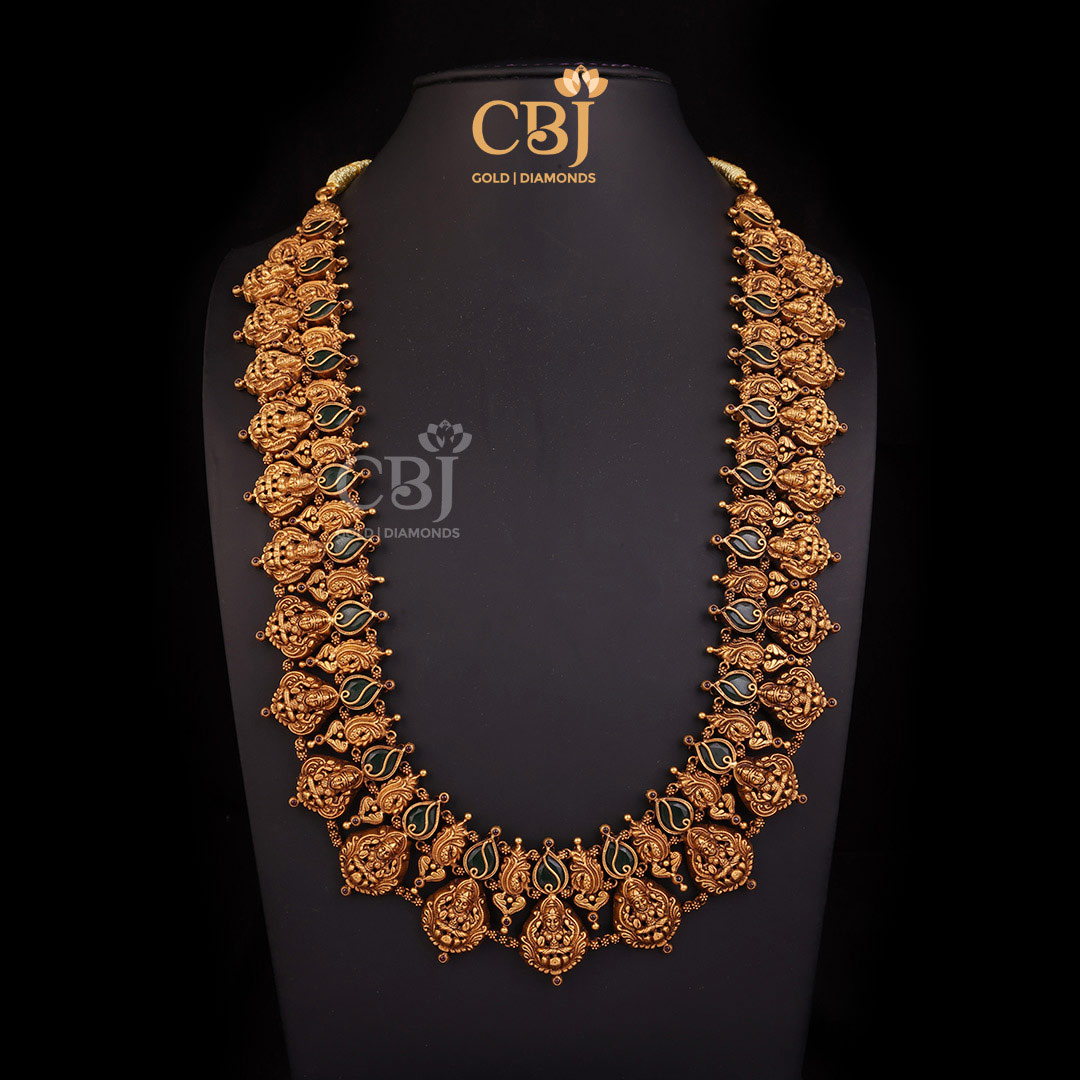A long antique Lakshmi Haram featuring a resplendent design with emerald stones.