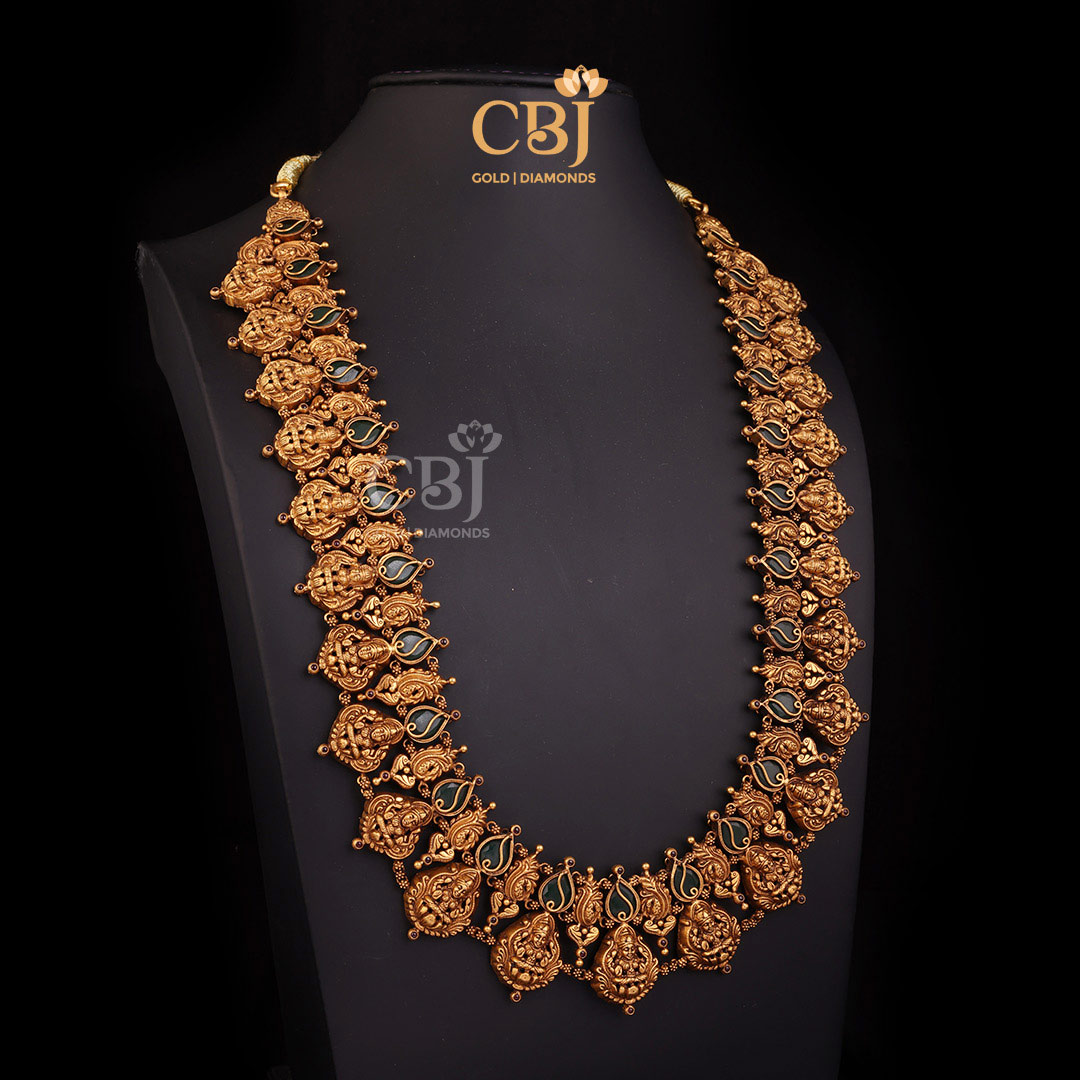 A long antique Lakshmi Haram featuring a resplendent design with emerald stones.