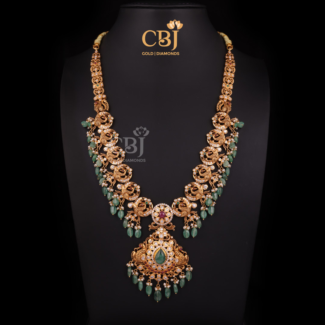 A captivating CZ Pachi long haram featuring peacock motifs adorned with emerald and micro-pearls.