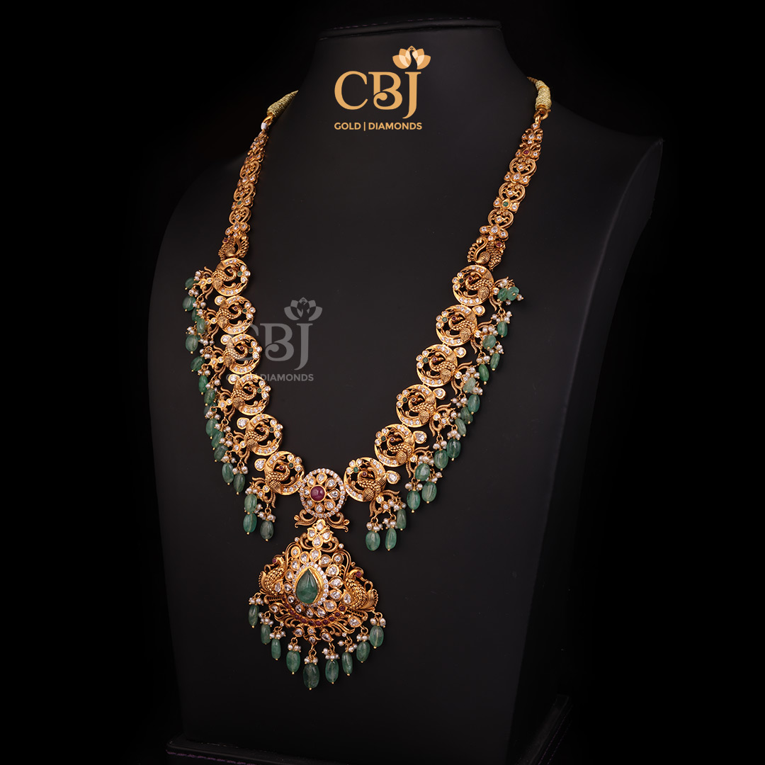 A captivating CZ Pachi long haram featuring peacock motifs adorned with emerald and micro-pearls.