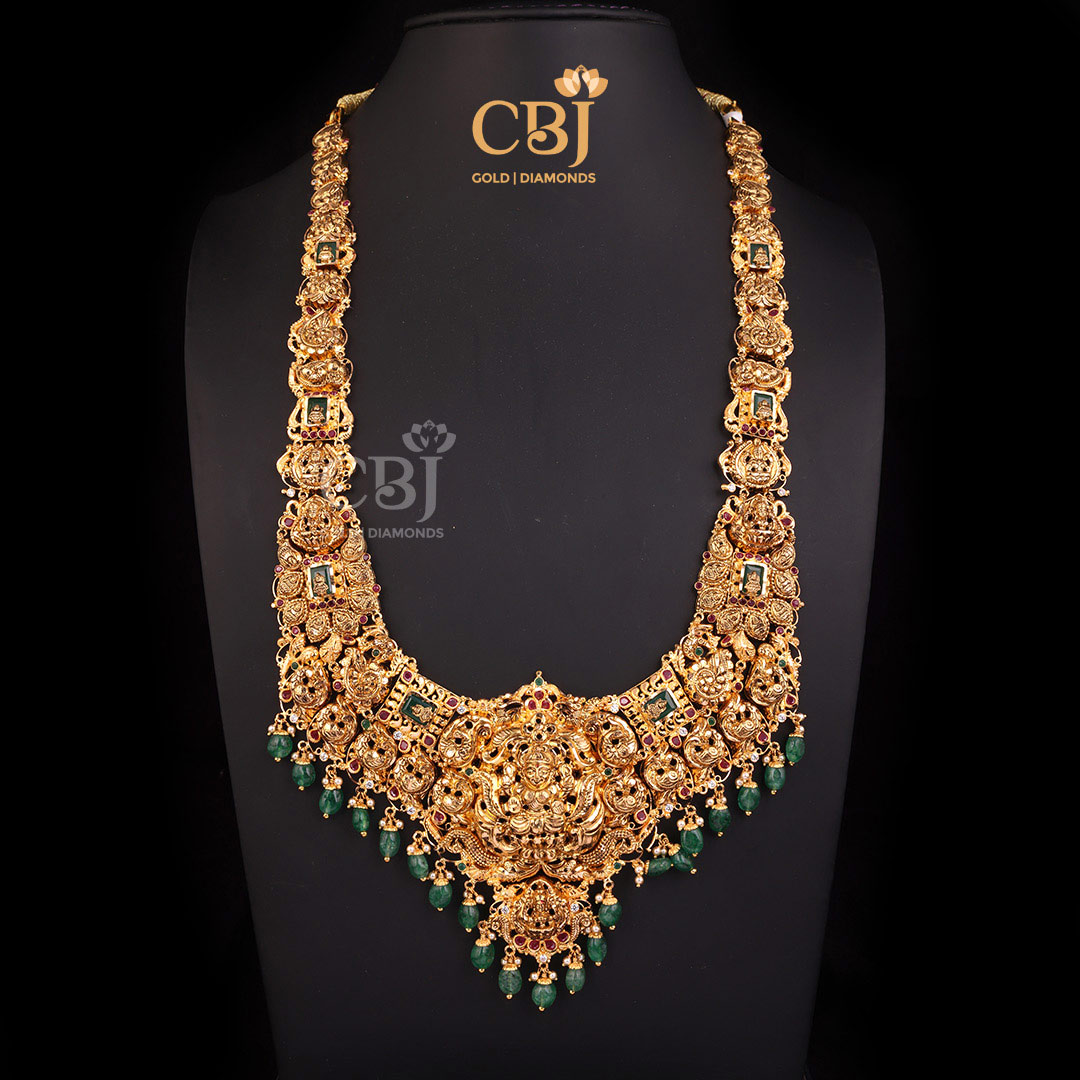 A rich grand CZ Pachi lightweight Lakshmi haram featuring emerald drops.