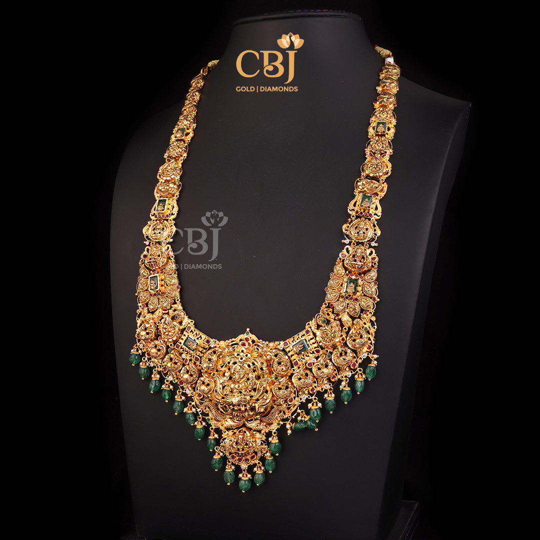 A rich grand CZ Pachi lightweight Lakshmi haram featuring emerald drops.
