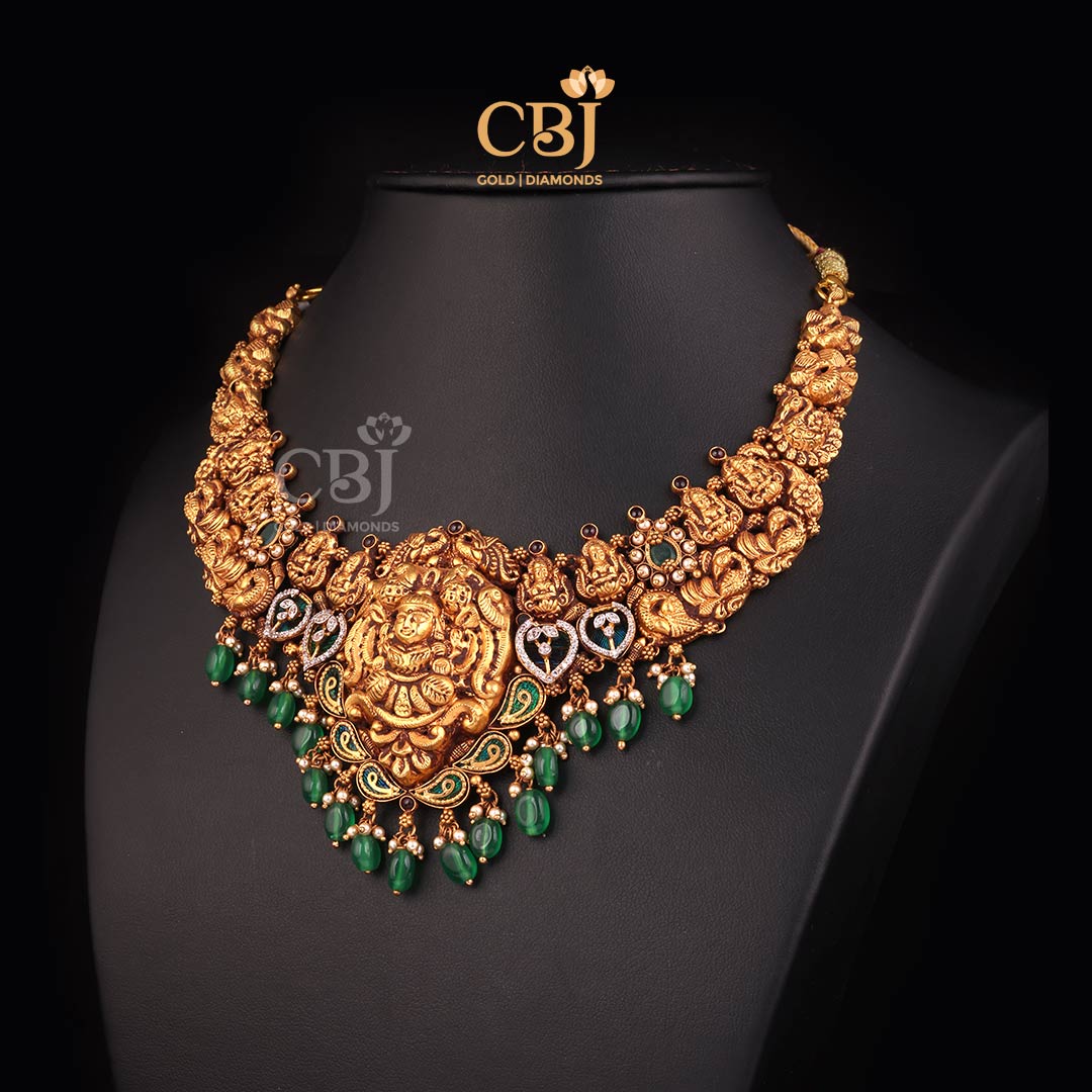 An intricately designed short antique Lakshmi necklace featuring emerald and cz stones.