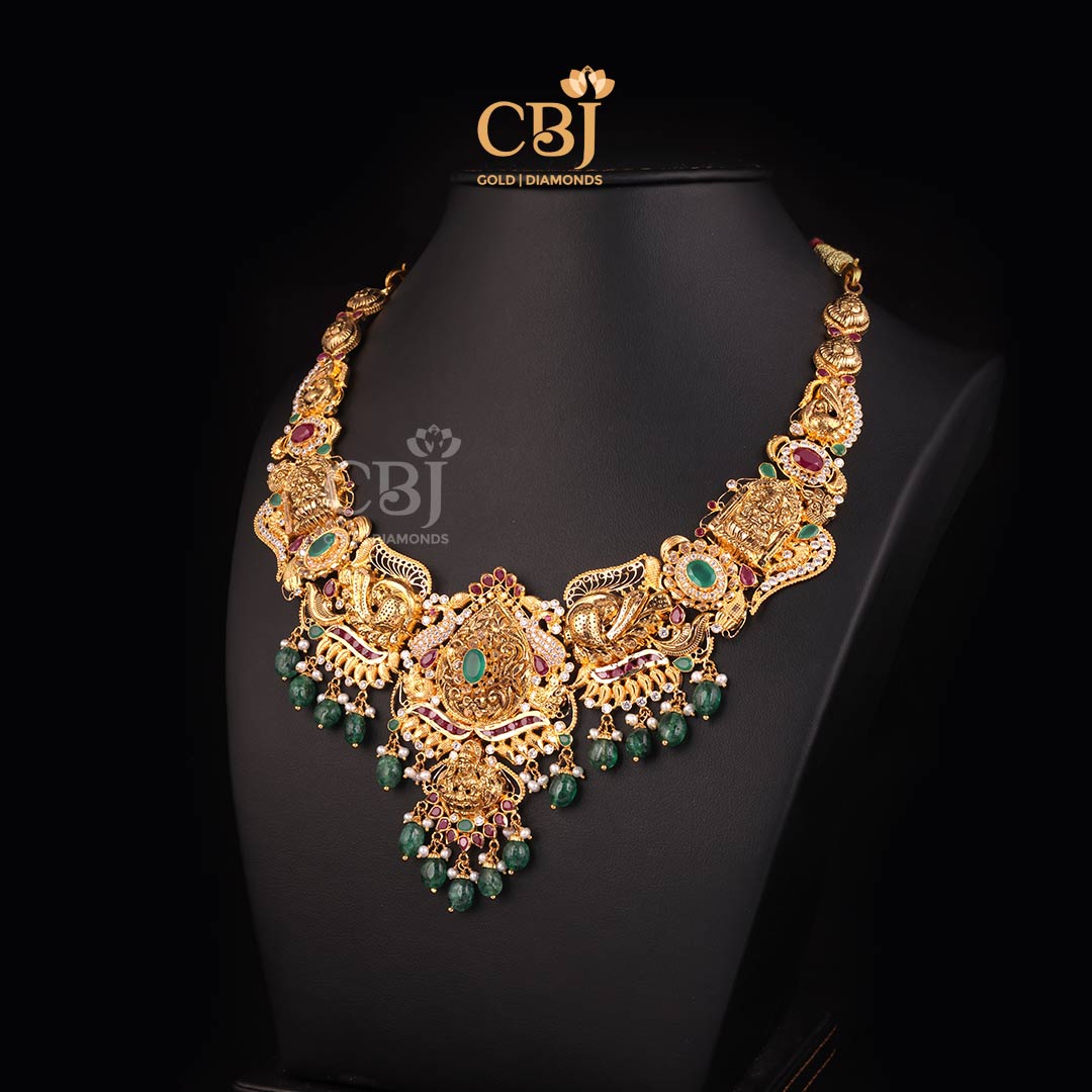 An enchanting CZ pachi light weight Lakshmi necklace featuring rubies and emeralds.